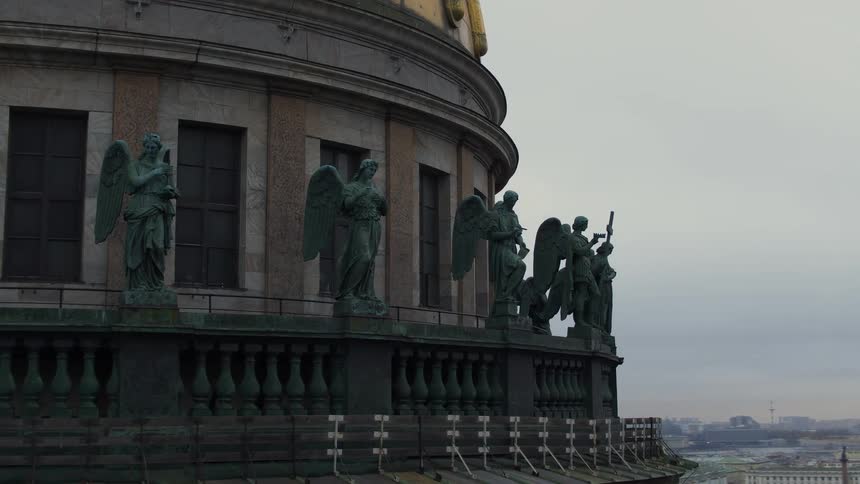 Statues stand just outside rail on domed landmark building towering over city