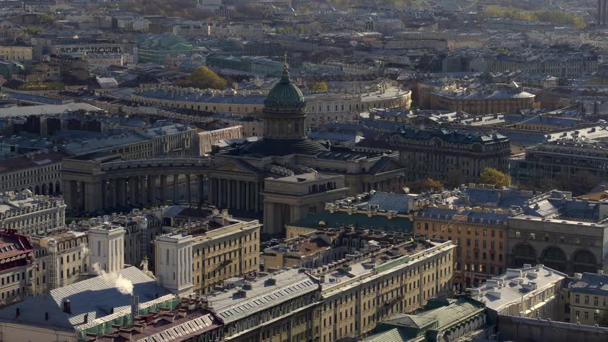 A tall domed building with beautiful architecture overlooks the crowded city of saint petersburg in russia as traffic moves on the streets