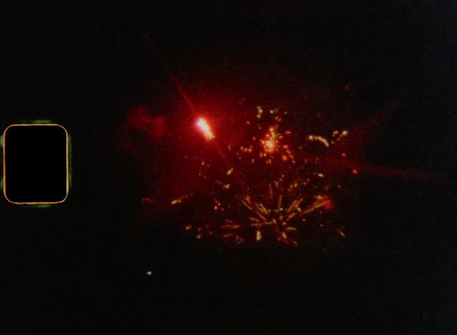 Multiple fireworks flashing and flaring in the night sky lighting up the skyline of a metropolis