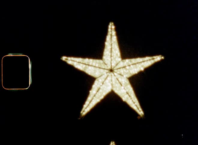 Old super 8mm film footage of a Christmas star shining outdoors at night symbolizing the star of Bethlehem as sign for hope togetherness and love on X-mas eve or Boxing Day during advent time on a cold December evening