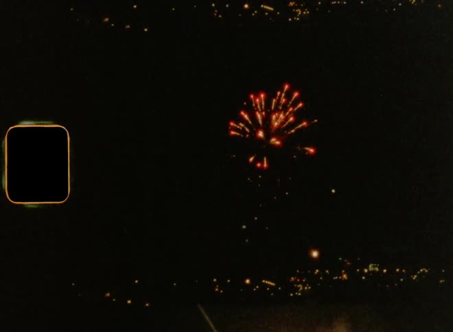 July 4th Fireworks exploding in a dark night sky over the skyline of a large city