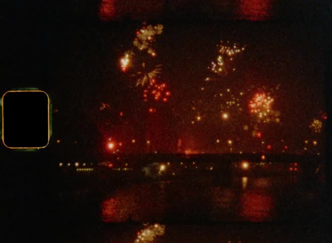 Fireworks shooting off behind a bridge on New Year’s Eve on retro film