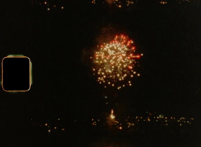 Super 8mm film of multiple fireworks that explode over skyline of a city as a New Year’s Eve tradition