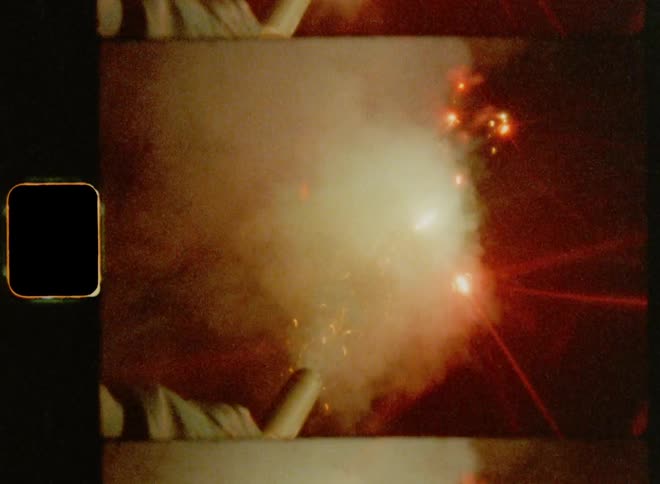 Man with coat sets off firework at night while celebrating the American Independence on July 4th
