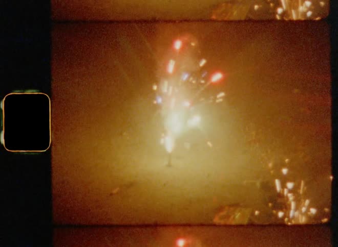 Colorful sparks and smoke from lit fireworks during a celebration on the street at night