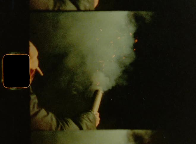 Young adult man with cap and coat sets off fireworks at night expressing independence and freedom