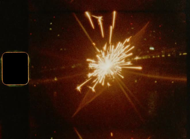 Happy anniversary celebration with holiday sparkler in front of a city skyline on Super 8mm film