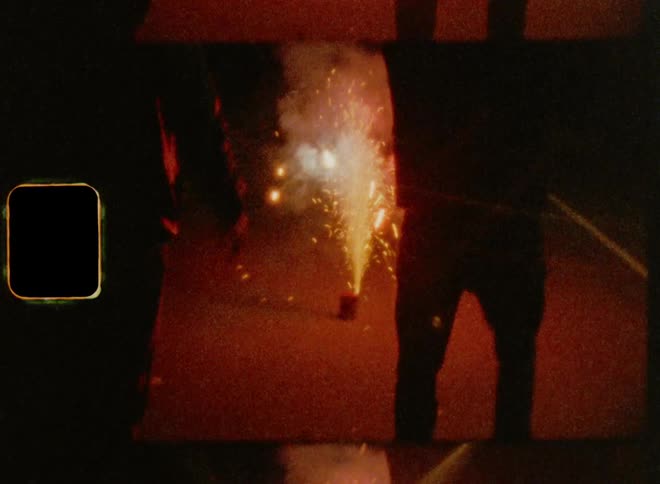 Silhouettes of two people dancing in front of fireworks on the streets