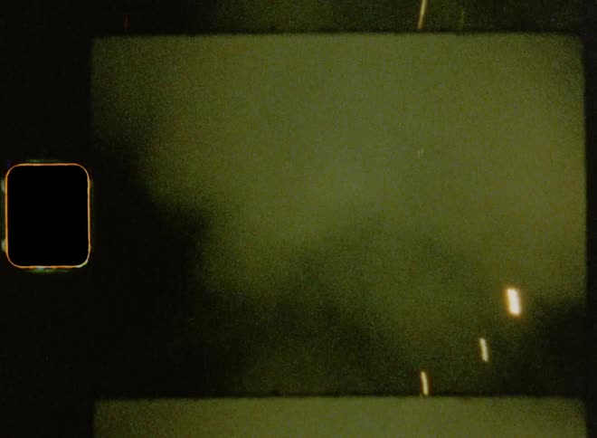 Several fireworks are launched from the street into the night time sky creating a cloud of smoke and bright sparkles
