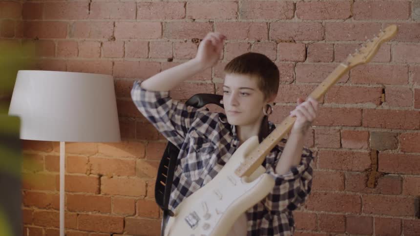 A woman picks up her guitar