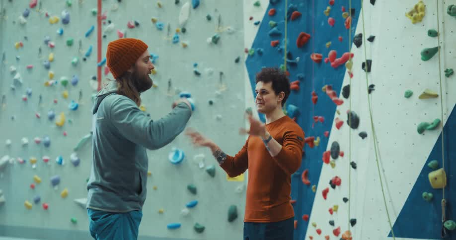 Two men warming up in front of climbing wall
