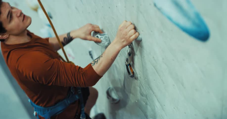 A man ascends an indoor climbing wall