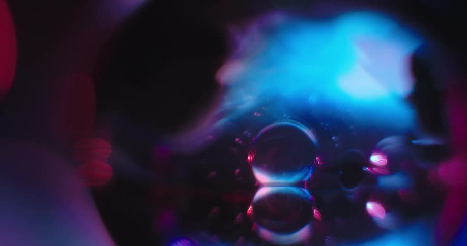 Bubbles of various sizes float in sphere colored in blues blacks and purples