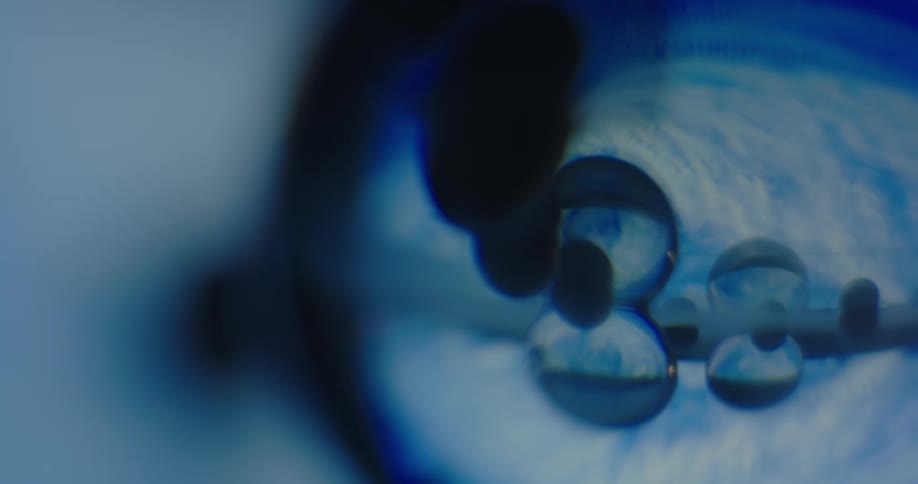 Light brightens and reflects from bubbles floating within blue sphere before fading again