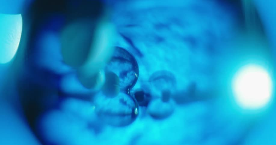 Several small glass sphere reflect images from a fly over of the earth from space