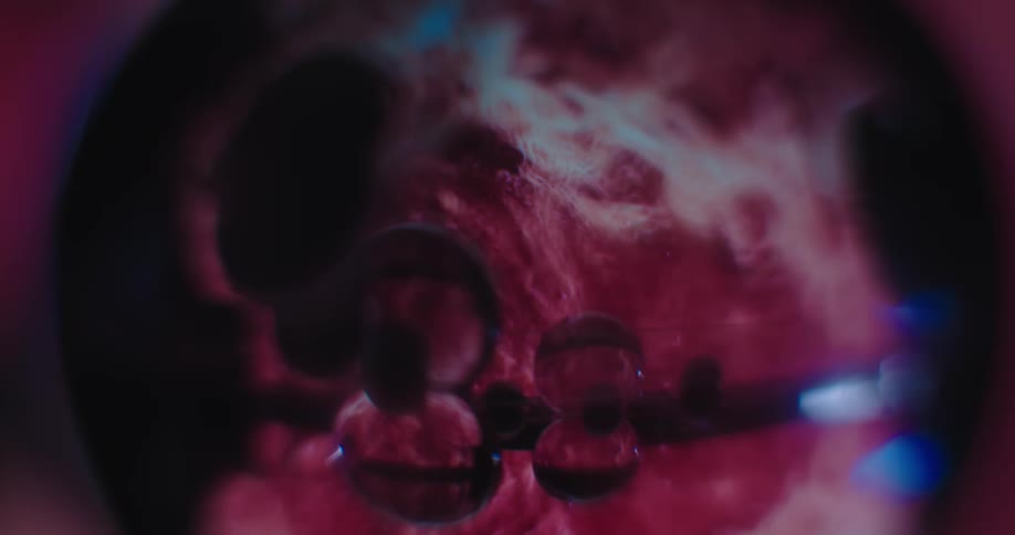 An up close of a red and pink spherical object rotating around
