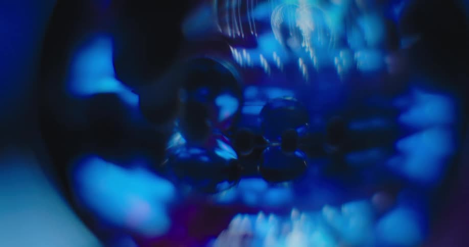 A blue sphere shows a reflection of an undulating jellyfish like creature