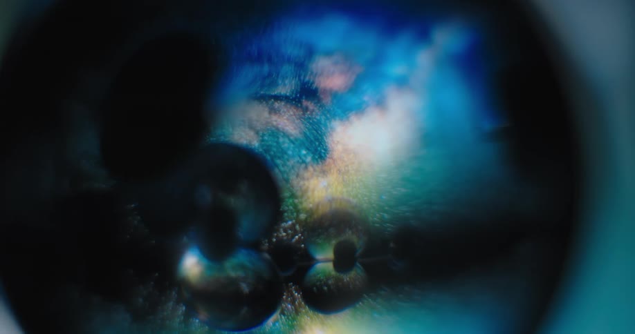 A planet rotates in the distance and reflects light and color on clear orbs