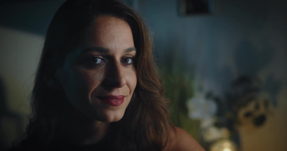 A woman poses for the camera and also pauses to touch up her lipstick