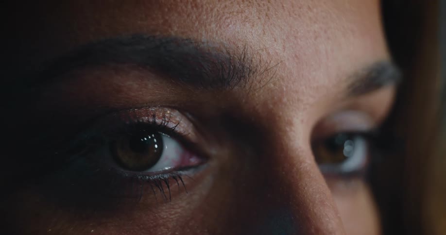 Woman with pale brown irises stares