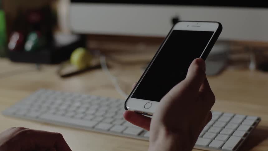 A person scrolls through a phone that isn't on