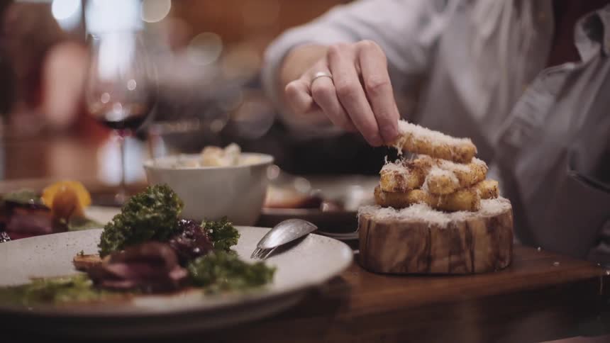 A person is drinking and eating at a table
