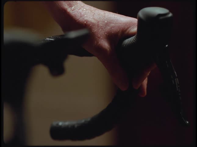 A man sweats while riding a bicycle indoors