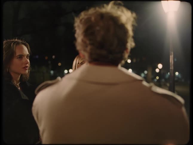 A group of friends drinking alcohol and smoking in the street at night