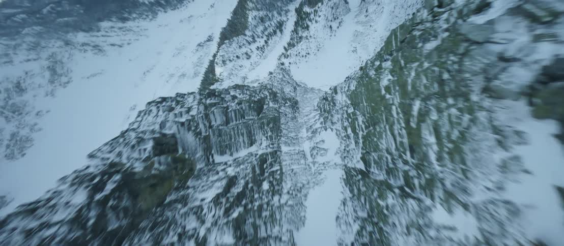 A thick blanket of snow covers the peaks and valleys of a mountain range