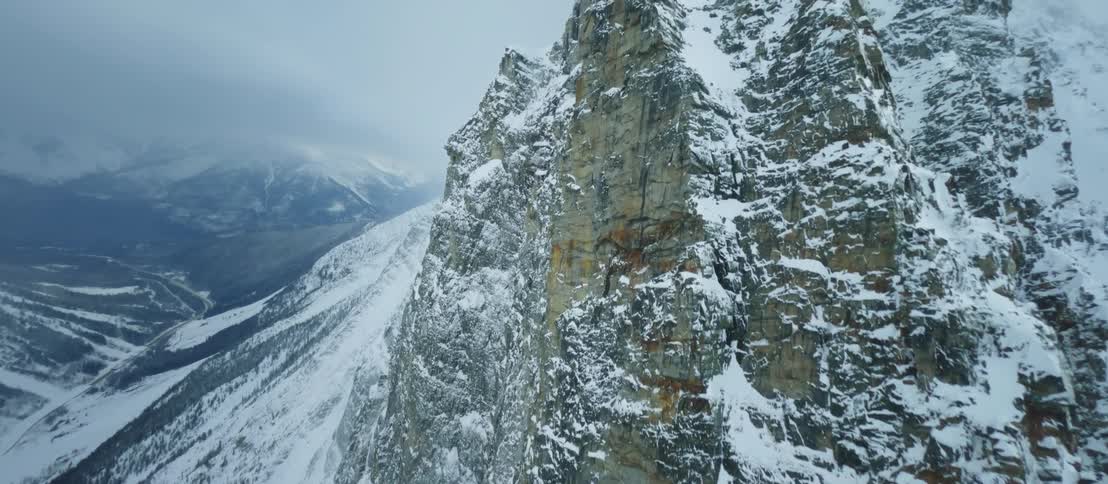 A snowcovered mountain range is shown via aerial view