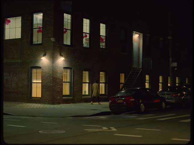Three people are standing on a street corner talking and a man and woman leave and the other woman stands for a moment before walking away