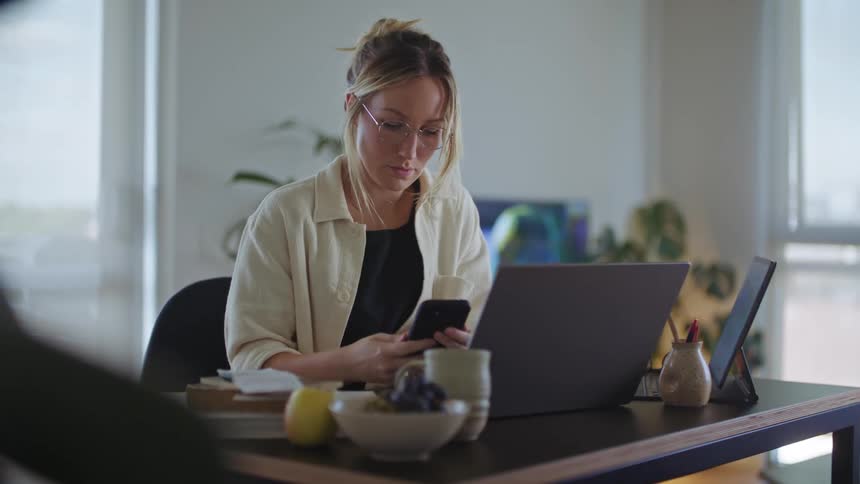A young woman is sitting down and is looking at her phone