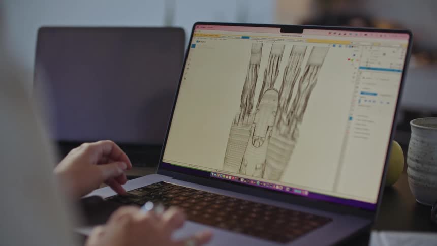 Woman adjusts robotic hand displayed on laptop monitor using the touchpad