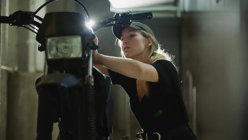 Woman works on making adjustments to motorbike