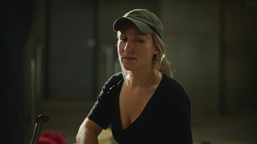 A young woman in a baseball cap smiling for a portrait