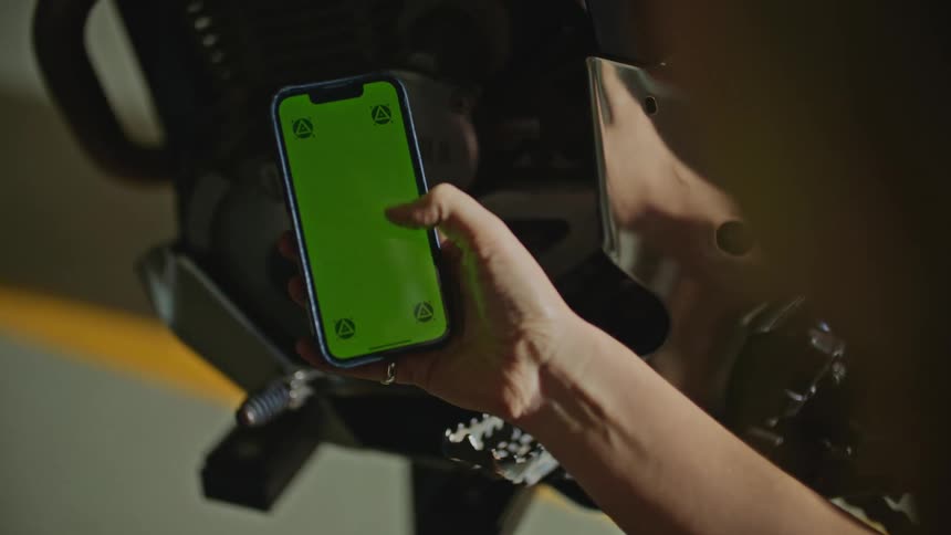 A woman scrolls through her phone while sitting next to her bicycle