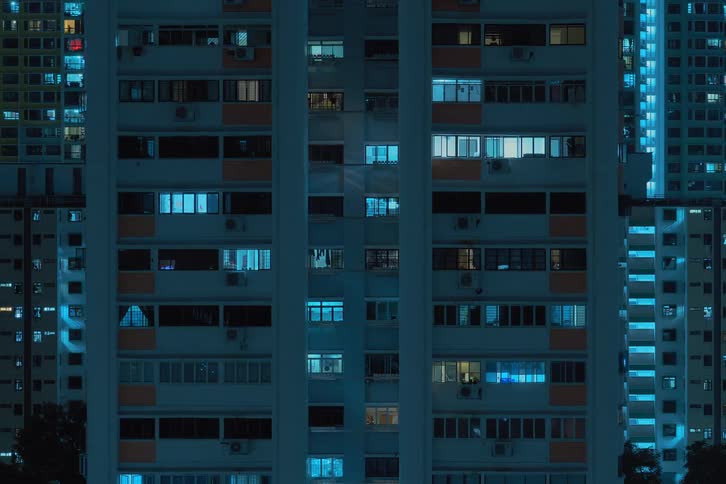 A time lapse of a building at only night shows lighted windows blinking quickly