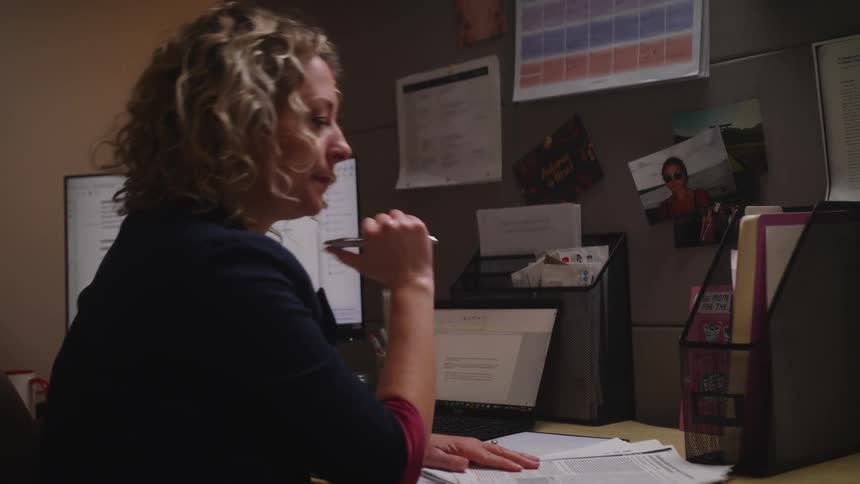 A woman is working at her desk
