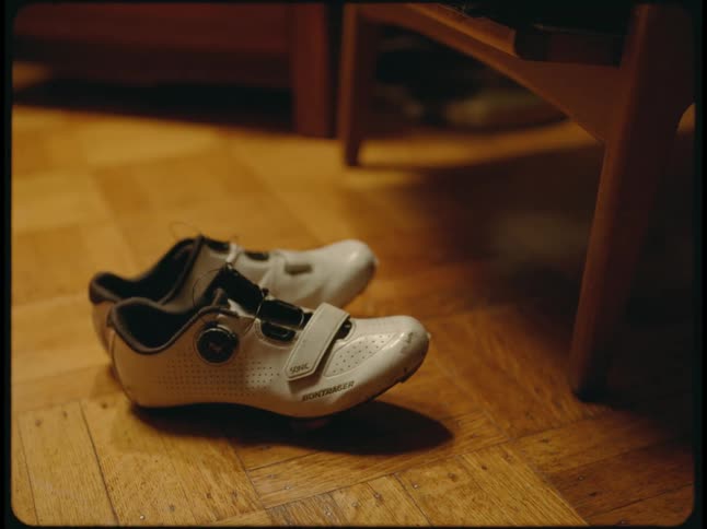 A pair of white sneakers on a hardwood floor