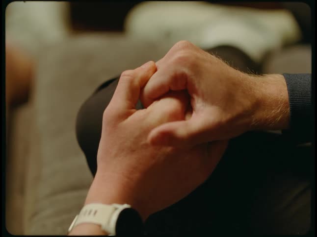 Two people hold hands