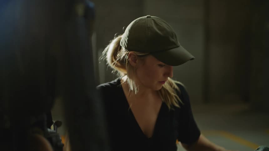 A woman is working on a car in a garage