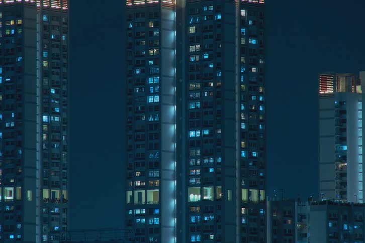 Aerial view of a city during the night time is displayed with fast blinking window lights