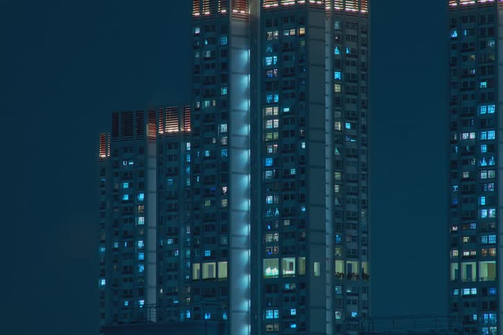 Lights in shades of blue flash inside futuristic towers and buildings