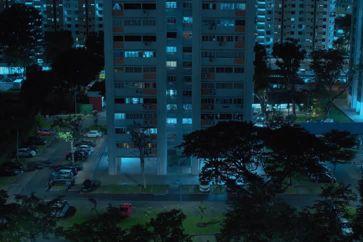 A super fast timelapse view of large apartment buildings in a city with moving cars and flickering lights