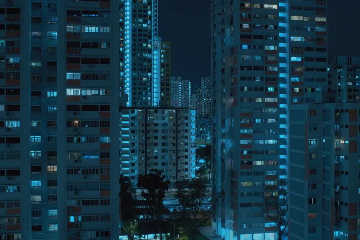 A time lapse of a city and tall buildings at night with lights flashing in the windows