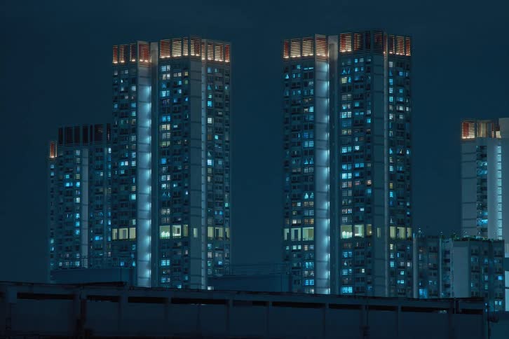 A time lapse shows several high rises only at night so window lights seem to blink and flicker