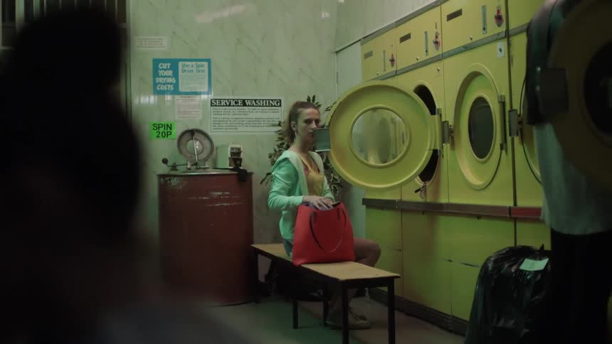 A woman puts clothes into the washing machine