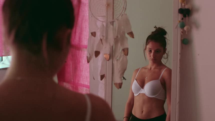 A female is looking at herself in a mirror