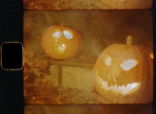 Two large carved pumpkin Jack O'Lanterns on stairs in front of an entrance door surrounded by smoke or fog outdoors at night on all hallows eve or a scary Halloween evening during fall season