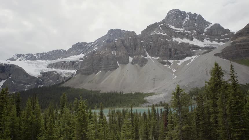 Grasses and pine trees surround a lake in a mountain valley